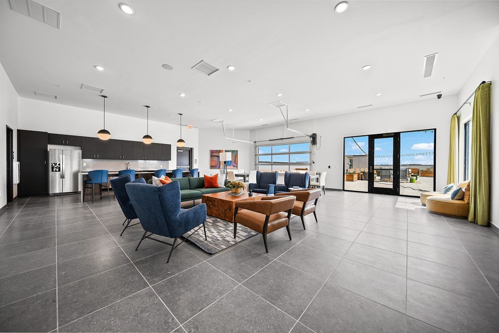 A modern living room with a kitchen in the background.