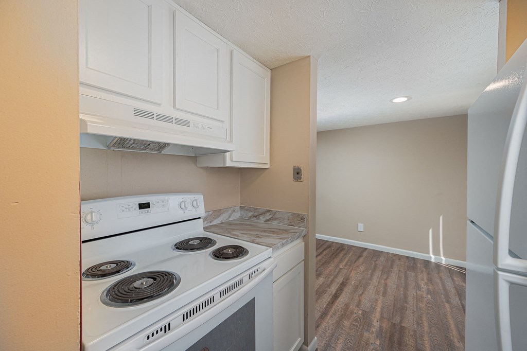 a kitchen with white cabinets and a stove and a refrigerator