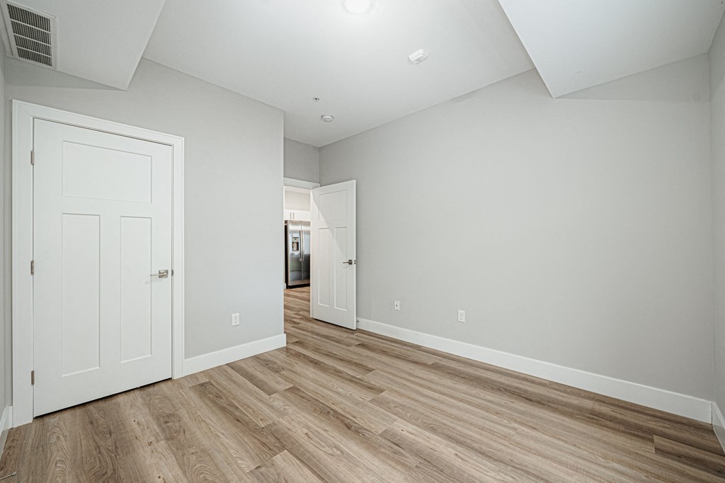 an empty living room with white walls and wood flooring