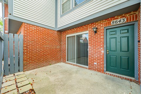 the entrance to a brick building with a green door