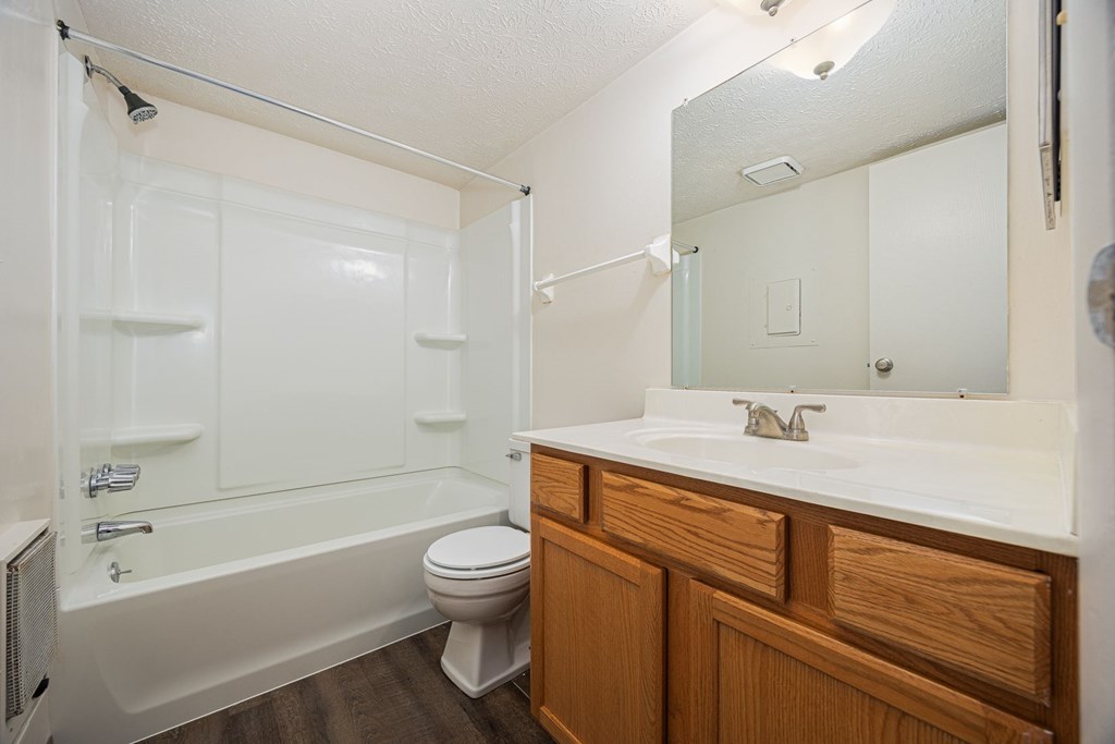 A white bathroom with a toilet, sink, and bathtub.