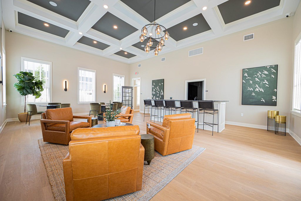 A living room with a large orange sofa and a chandelier hanging from the ceiling.