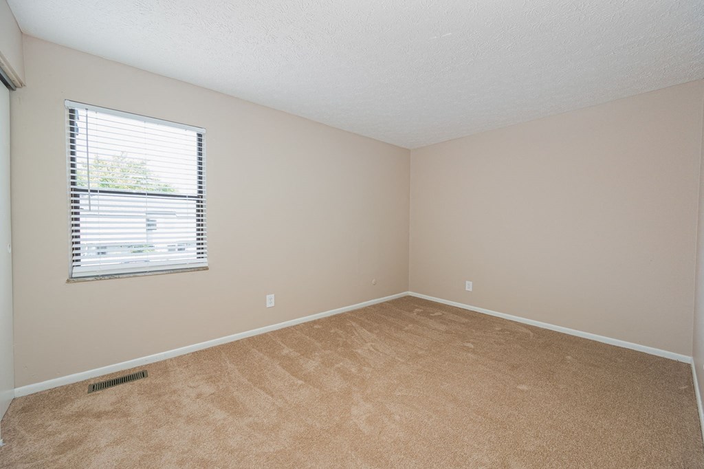 an empty room with carpet and a window