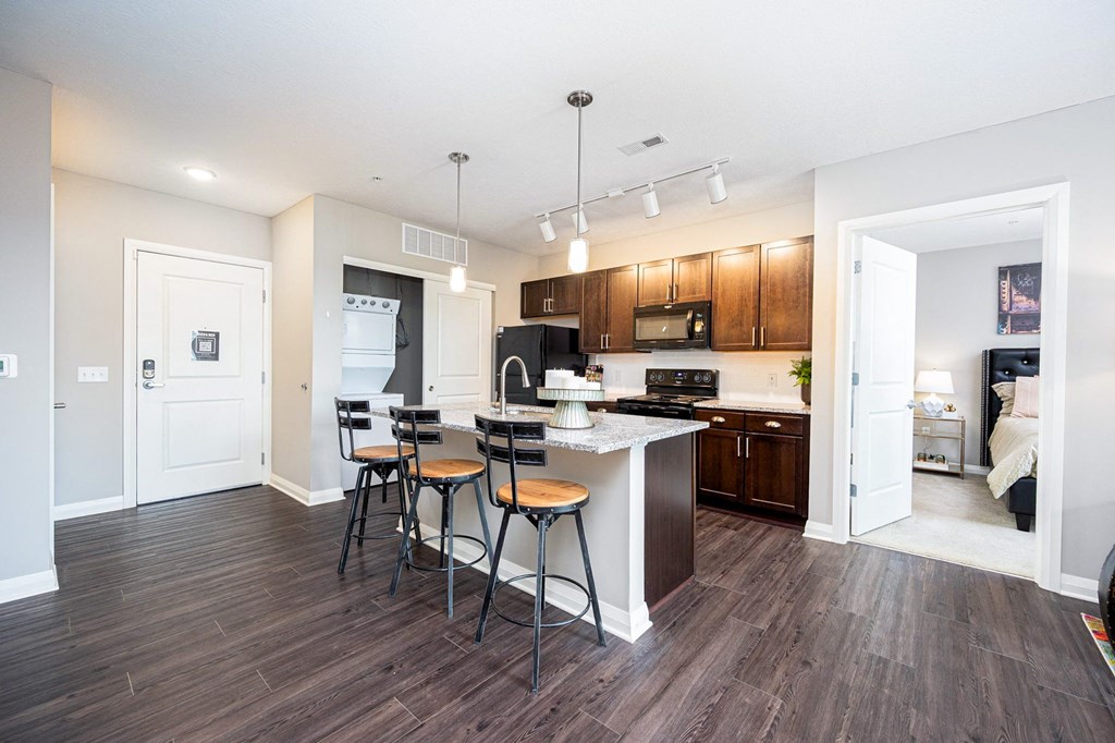 a kitchen with a bar and stools in a living room