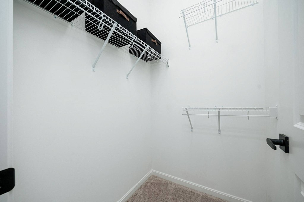 a room with white walls and two wire racks on the wall