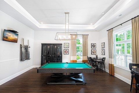 a living room with a pool table and a chandelier