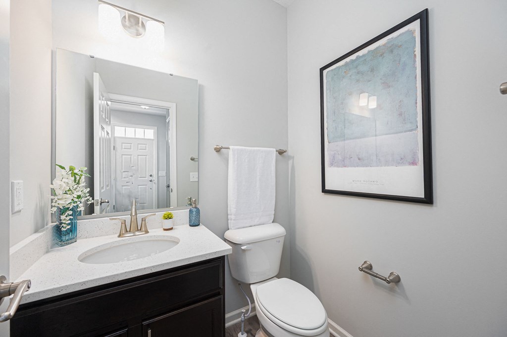 a bathroom with a toilet and a sink and a mirror
