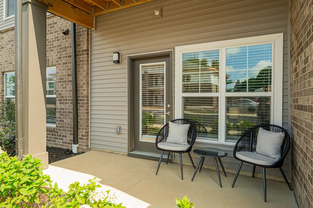 a patio with two chairs and a table on a porch