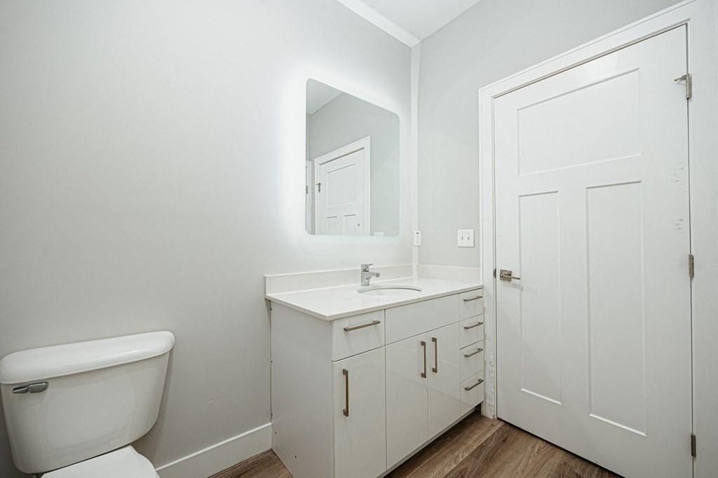 a bathroom with a toilet sink and mirror