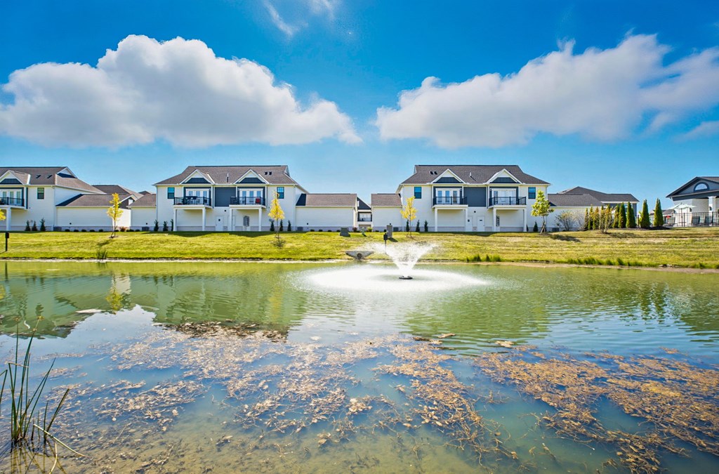 A row of houses with a fountain in the foreground.