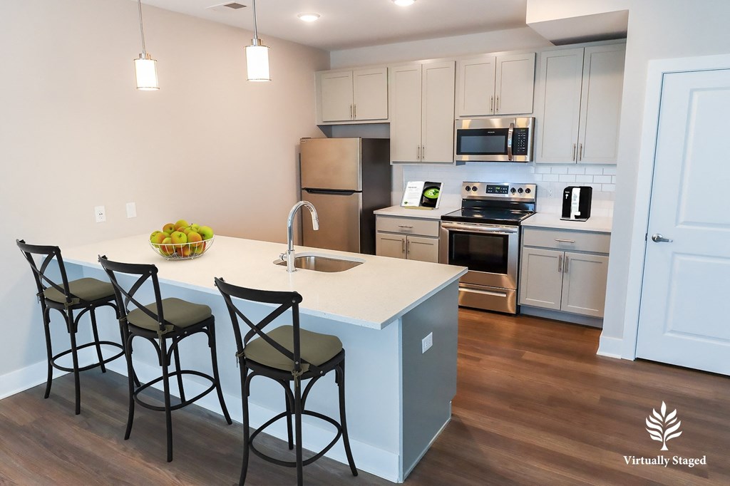 a kitchen with white cabinets and a blue island with three stools