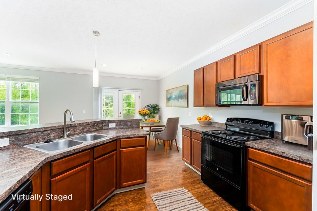 A kitchen with wooden cabinets and a black stove top oven.