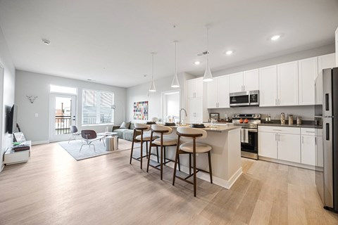 A modern kitchen with a bar stool and a dining table.