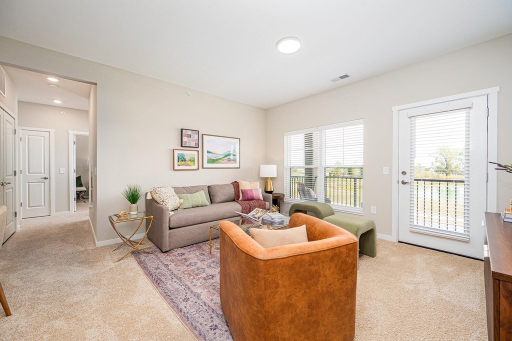 A living room with a couch, chair, and pictures on the wall.