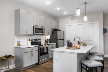 A kitchen with a white countertop and grey cabinets.