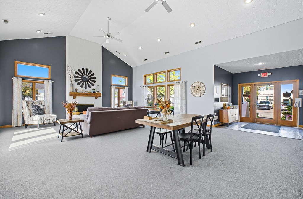 A living room with a grey carpet and a brown couch.