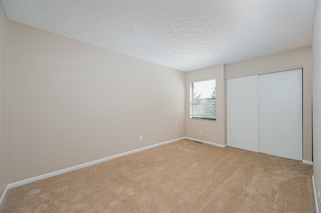 an empty living room with white walls and a window