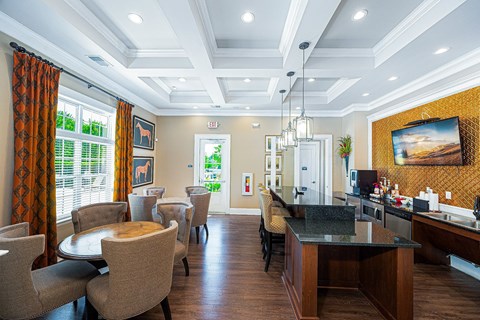 a living room with tables and chairs and a bar