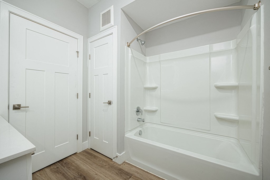 a bathroom with a tub and a sink and a door