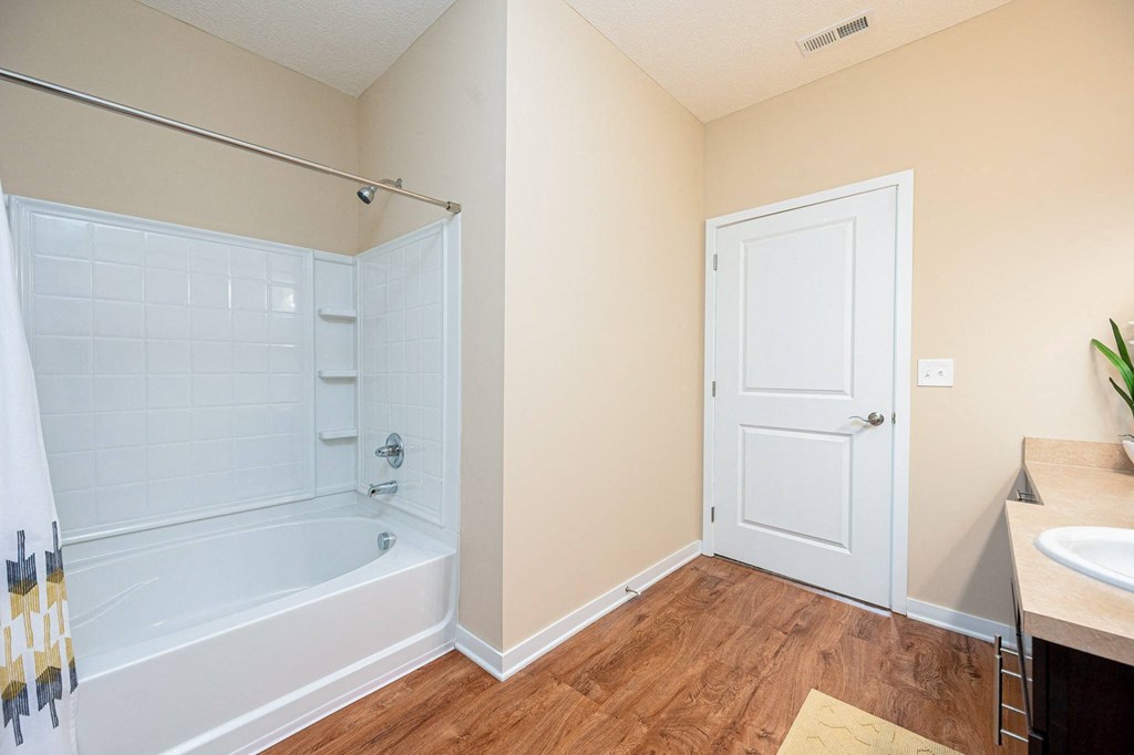 a bathroom with a tub and a shower and a sink