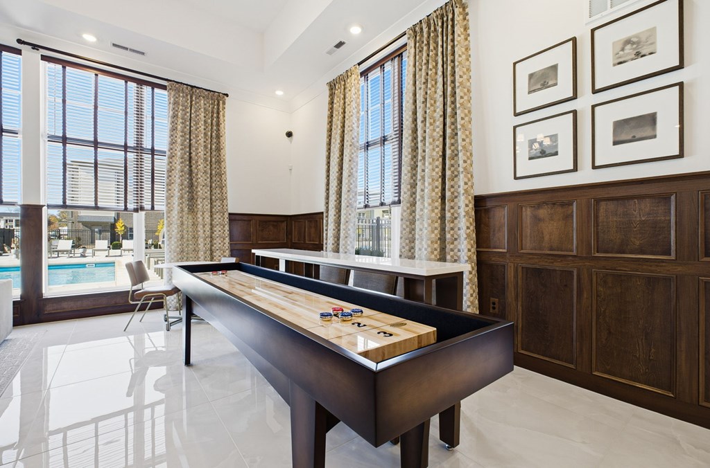 A pool table in a room with a window and curtains.