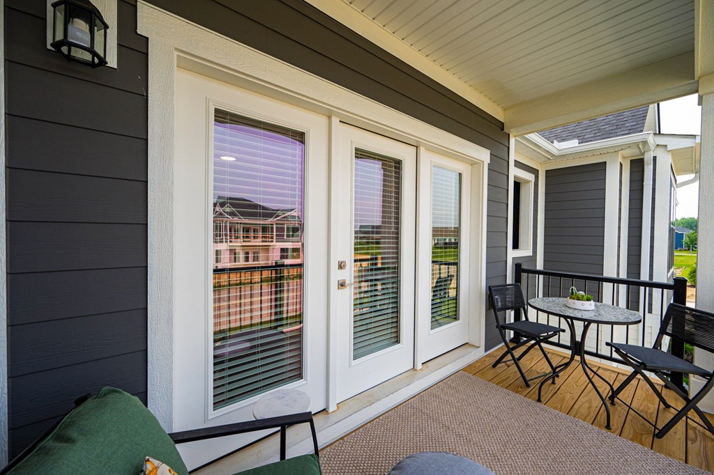 A patio with a table and chairs and a view of a house.