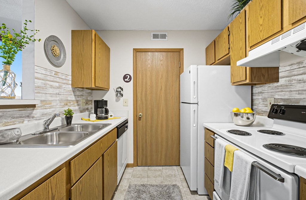 A kitchen with wooden cabinets and a white refrigerator.