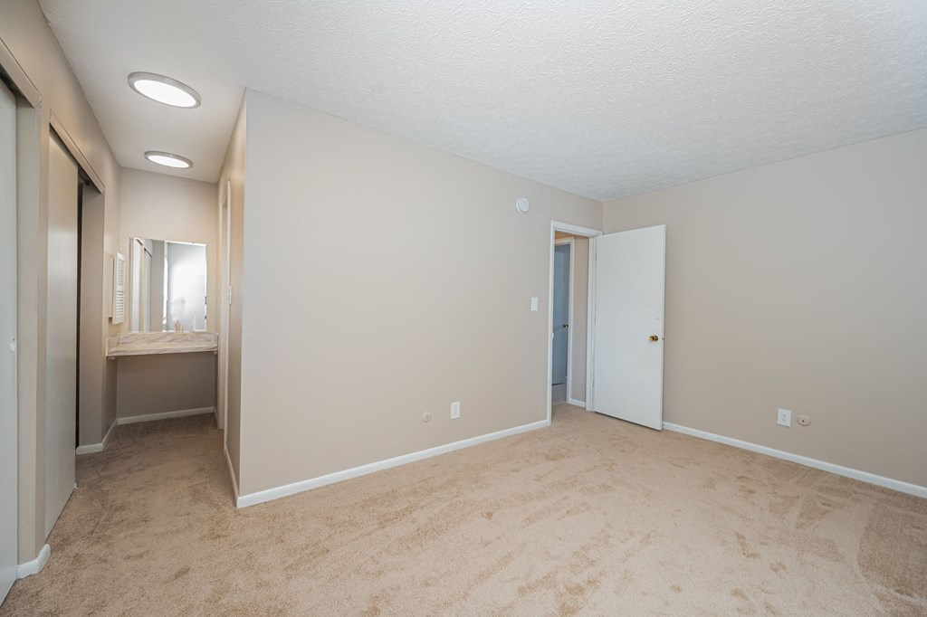 an empty living room with a bathroom and a closet