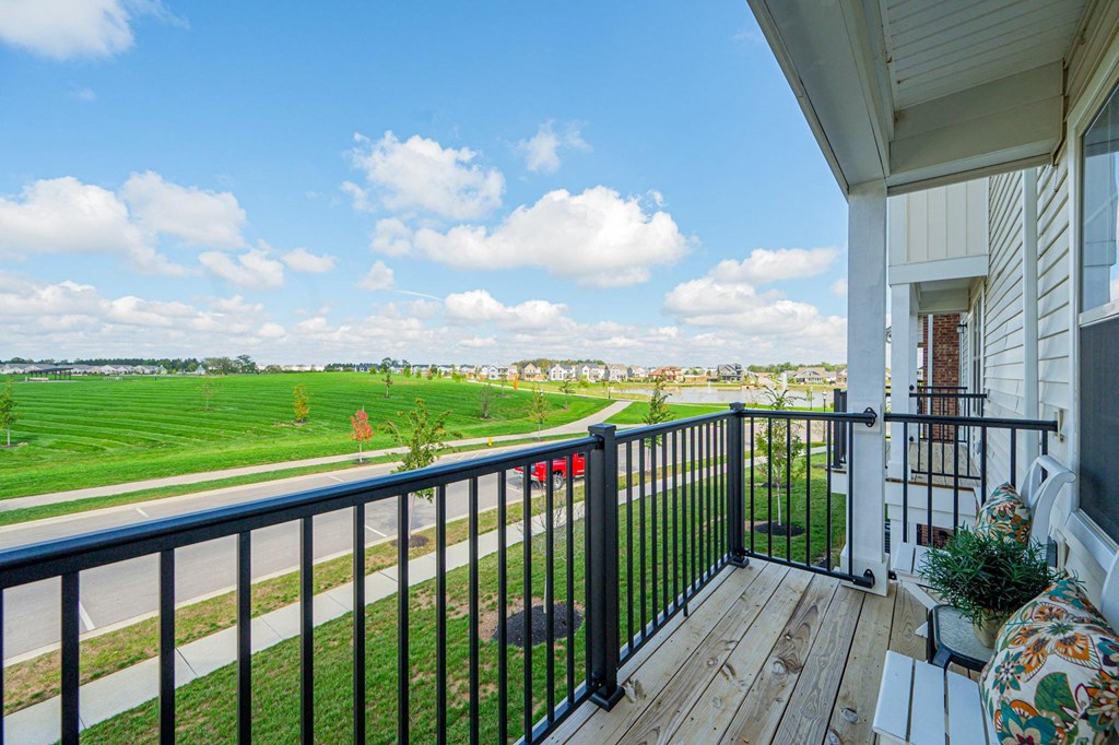 the view from the balcony of a house overlooking a field and a city