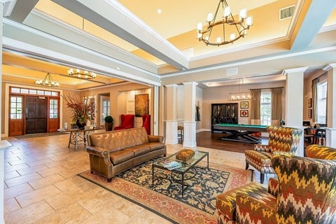 a living room with couches and a pool table