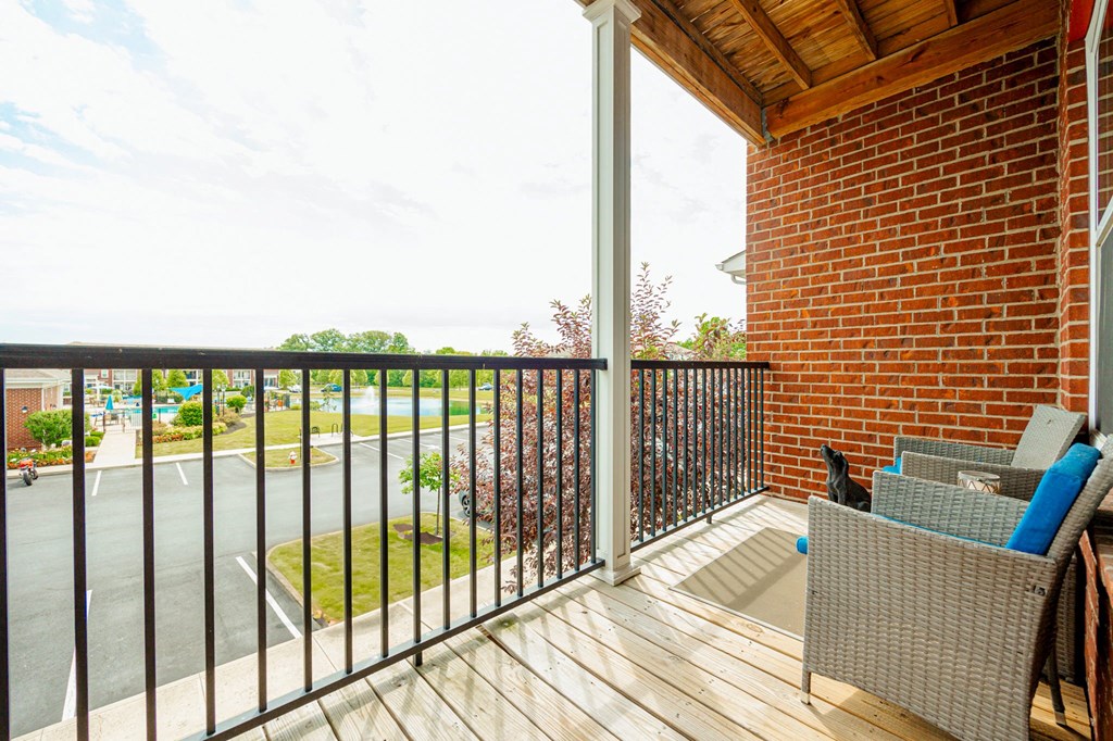 a balcony with a brick wall and a wooden deck