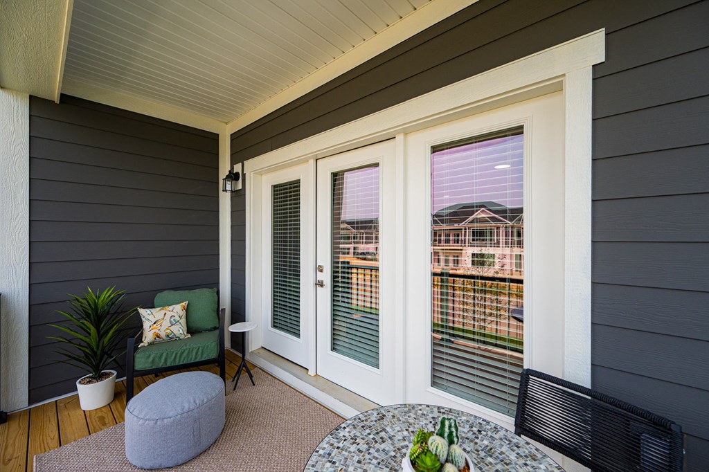 A small balcony with a table and chairs.