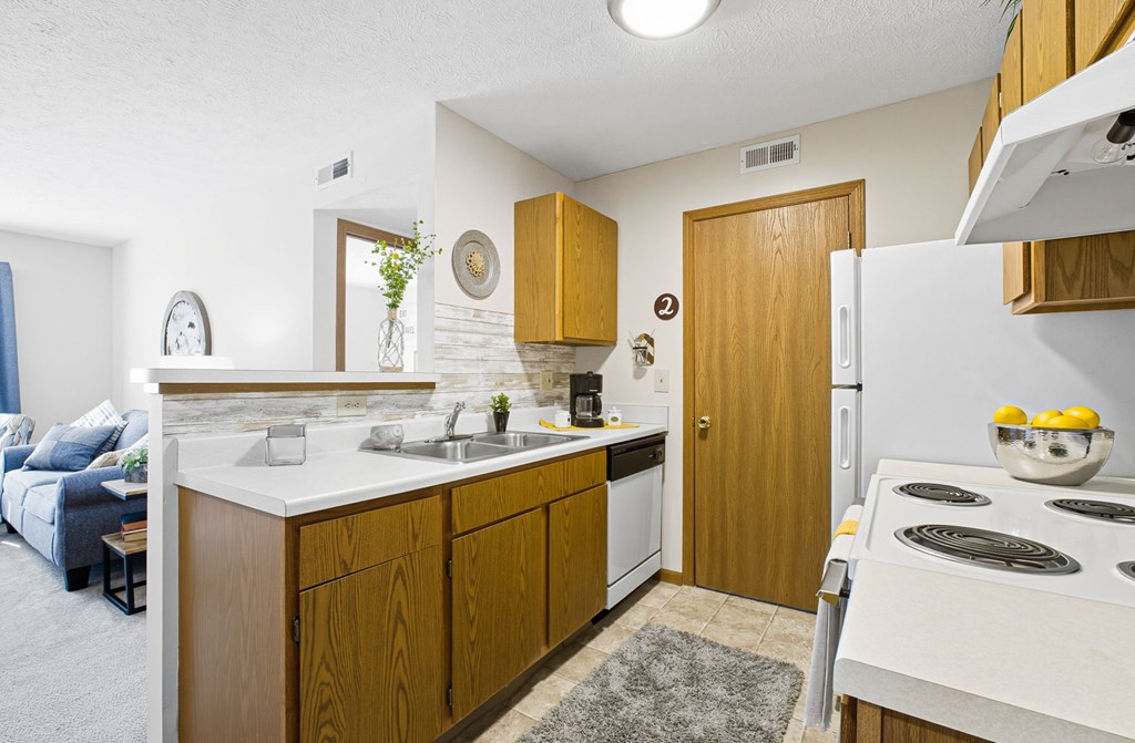 A kitchen with wooden cabinets and a white stove top oven.