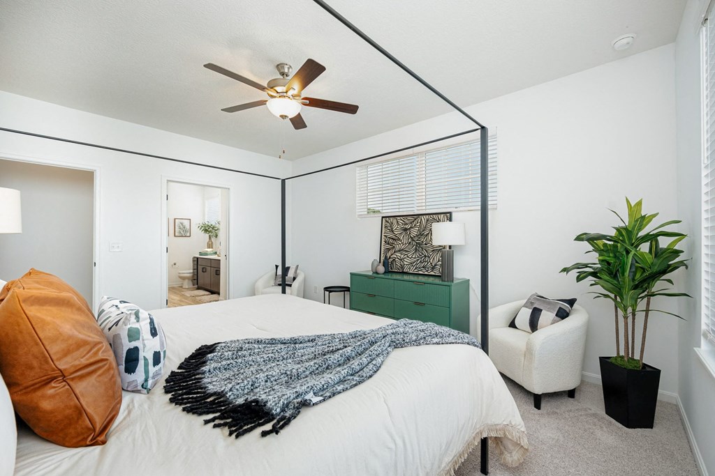 a bedroom with a large bed and a ceiling fan