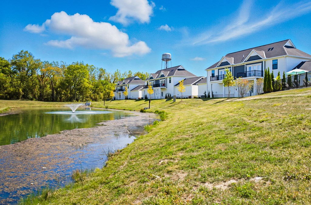 A house with a water fountain in front of it.