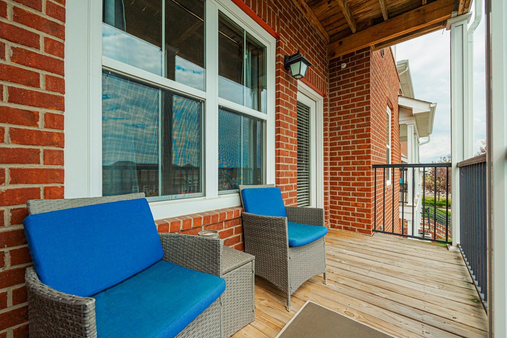 a patio with chairs and a brick wall