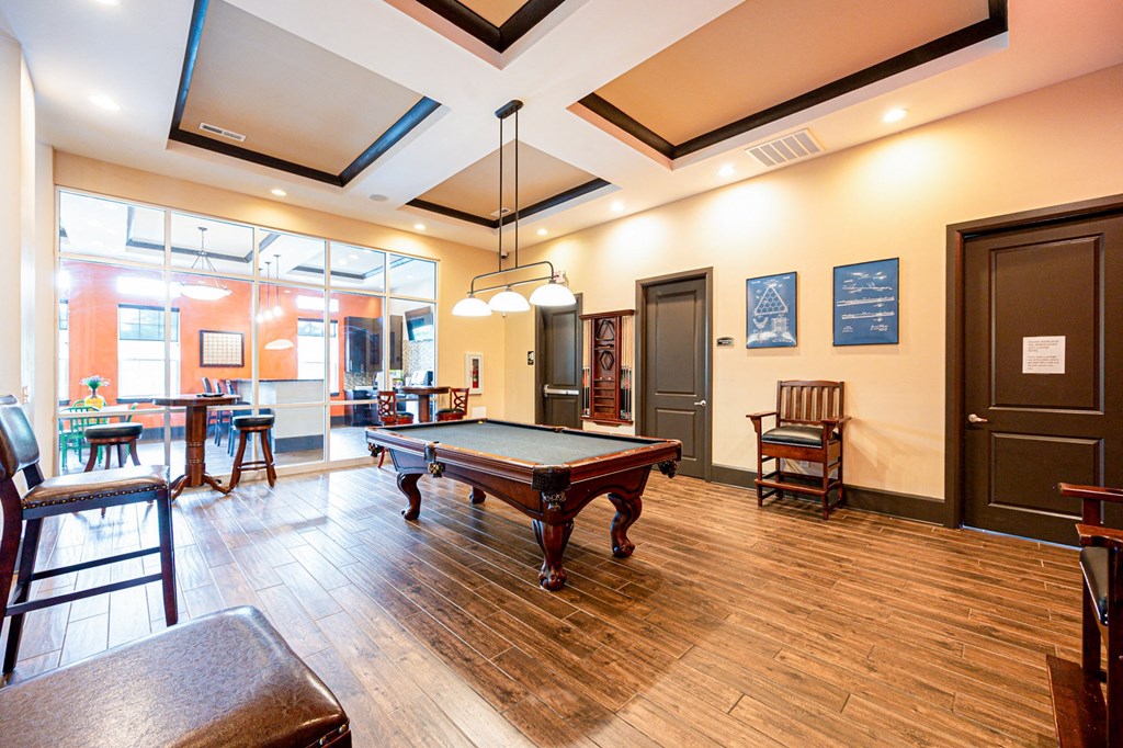 a game room with a pool table and a bar