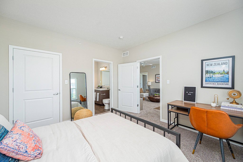 a bedroom with a bed and a desk with a mirror