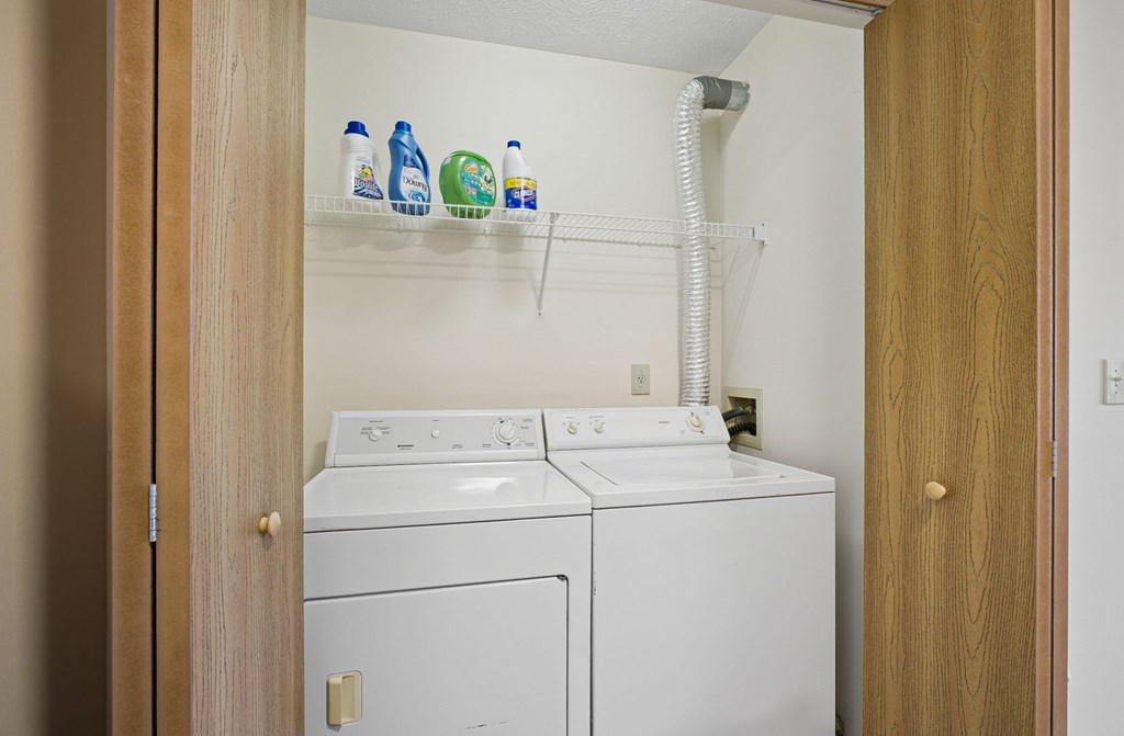 A white washing machine and dryer in a small laundry room.
