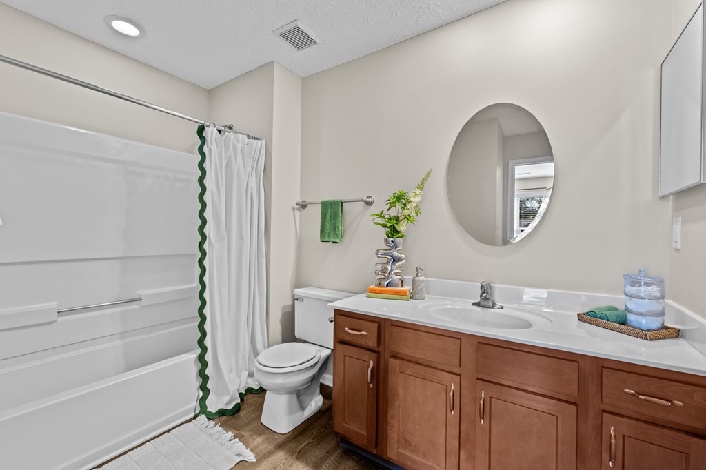 A bathroom with a toilet, sink, and shower.