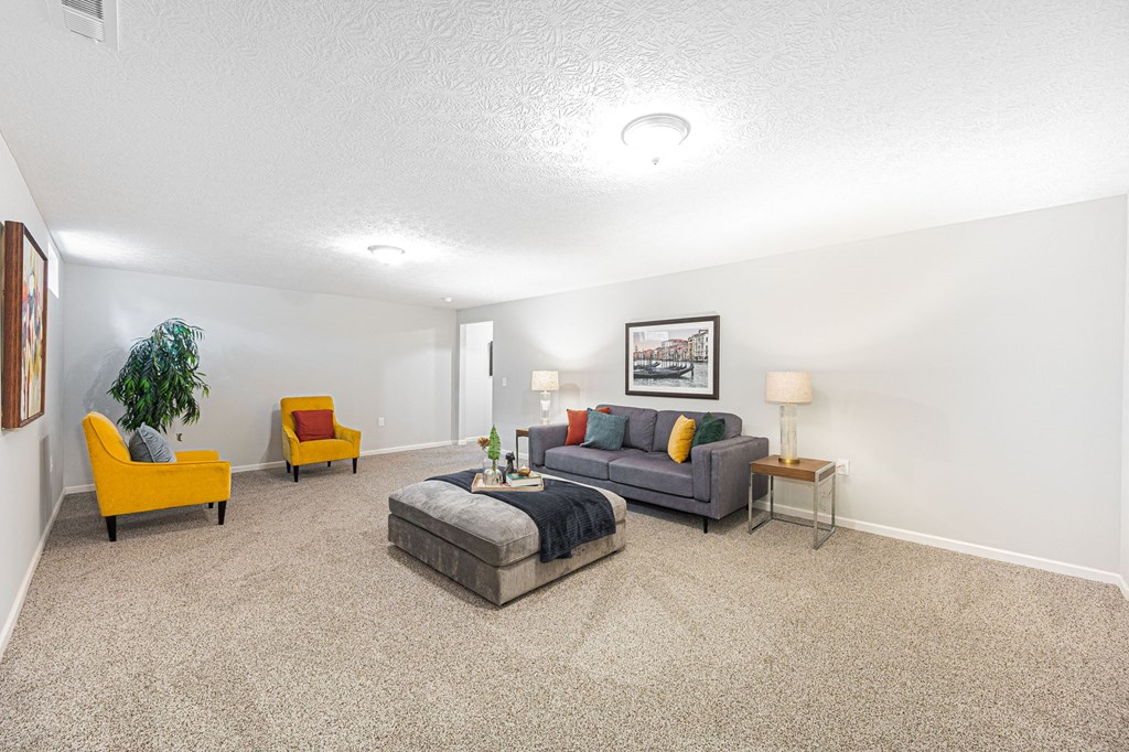 finished basement with a couch and chairs and a