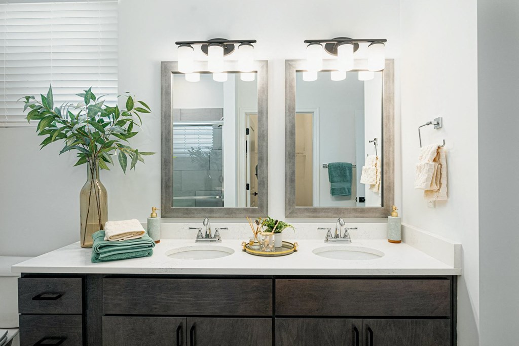 a bathroom with two sinks and three mirrors