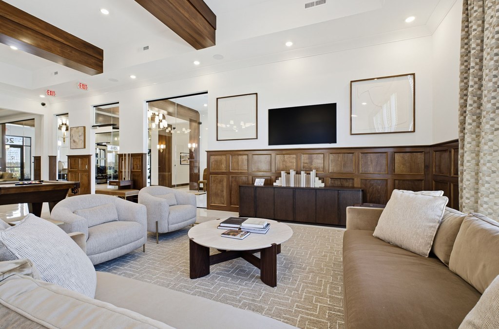 A living room with a brown couch and a white chair.