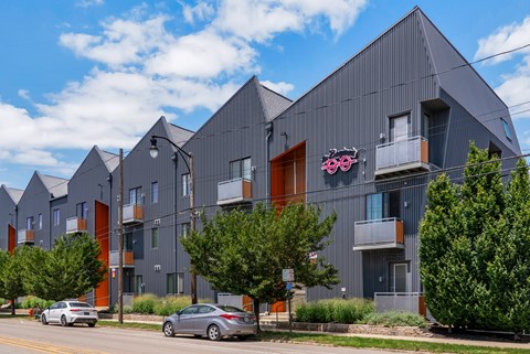 A modern building with a grey facade and a red door.