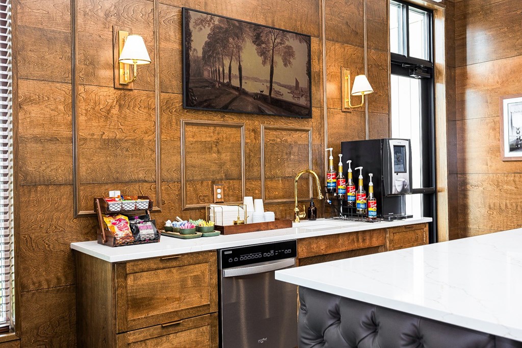 A kitchen with a white counter top and a black dishwasher.