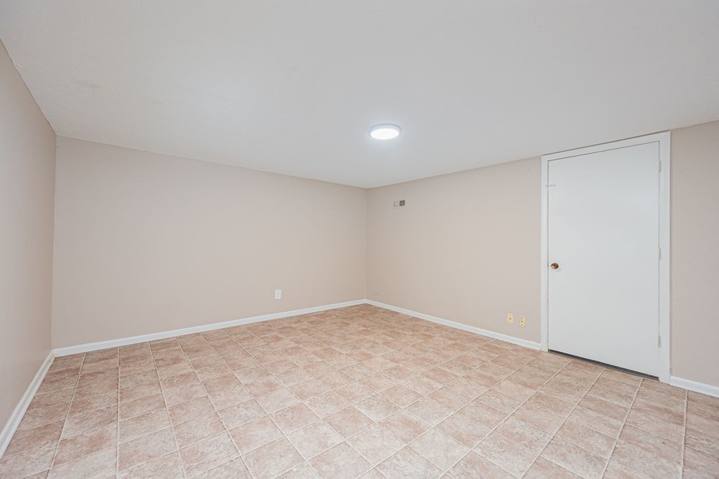 an empty living room with a door to a closet