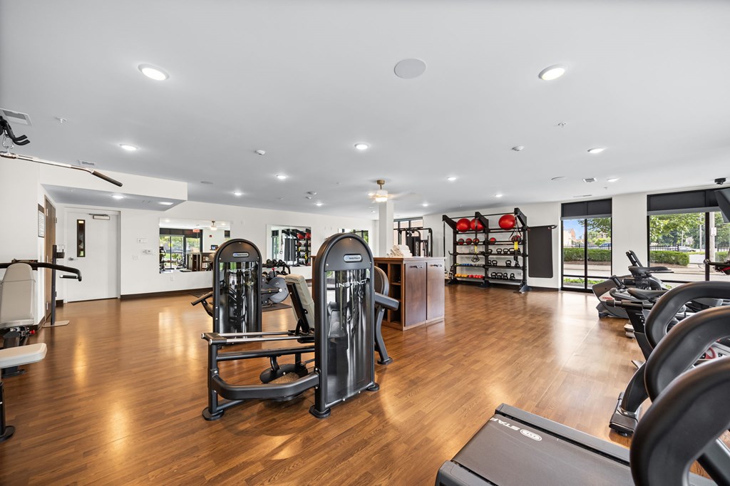 A gym with a variety of equipment including treadmills, weights, and exercise machines.