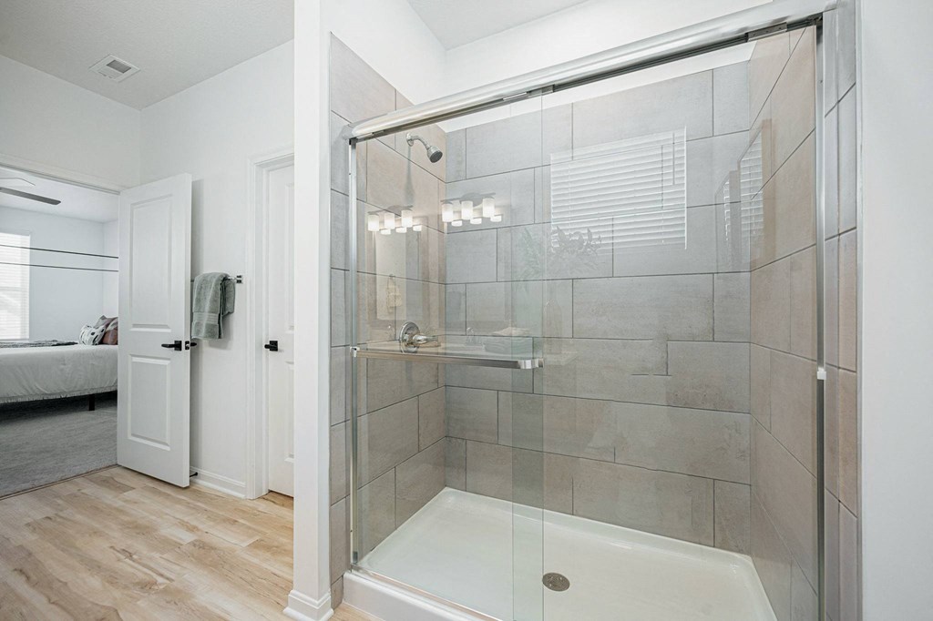 a bathroom with a shower with a glass door