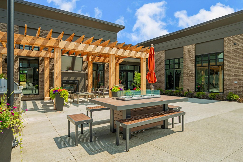 a patio with tables and benches outside of a building