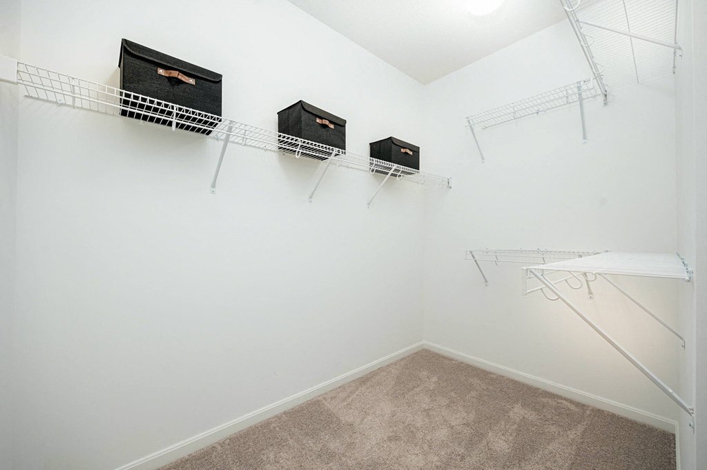 a spacious closet with shelves and hanging racks on the wall
